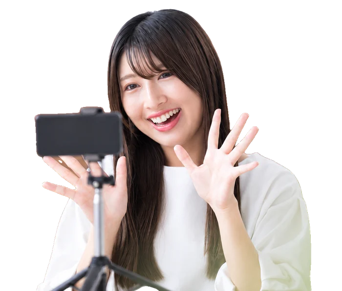 スマホに向かって笑顔で手を振る女性（イメージ）