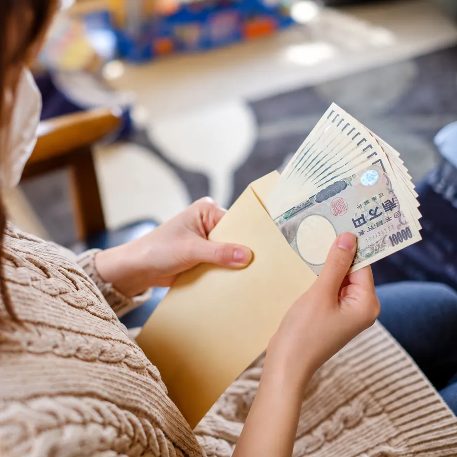 お給料の封筒を持つ手元（イメージ）